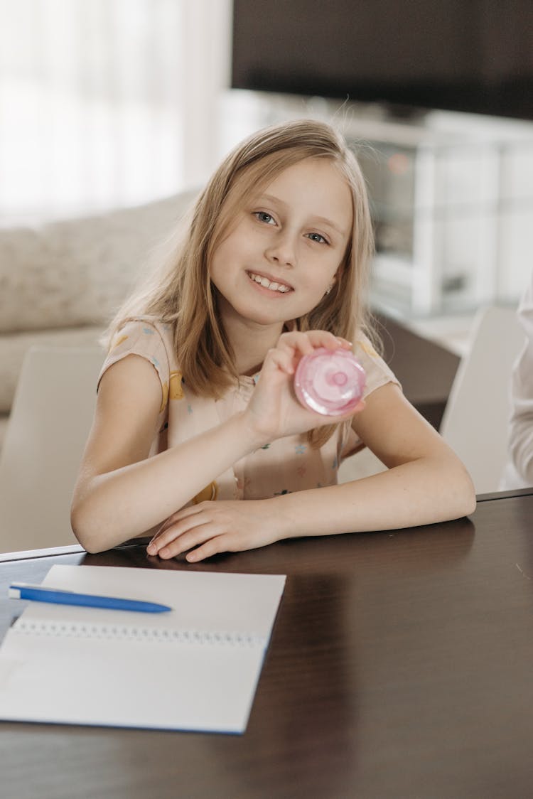 Smiling Blonde Girl With Toy And Notebook