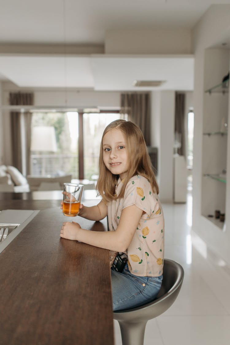 A Girl Drinking A Glass Of Juice