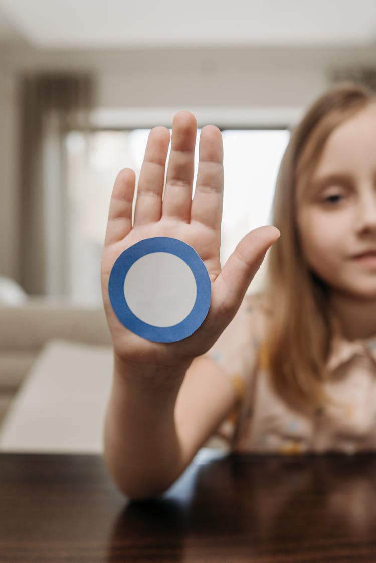 A Kid With Blue And White Sticker On Her Hand