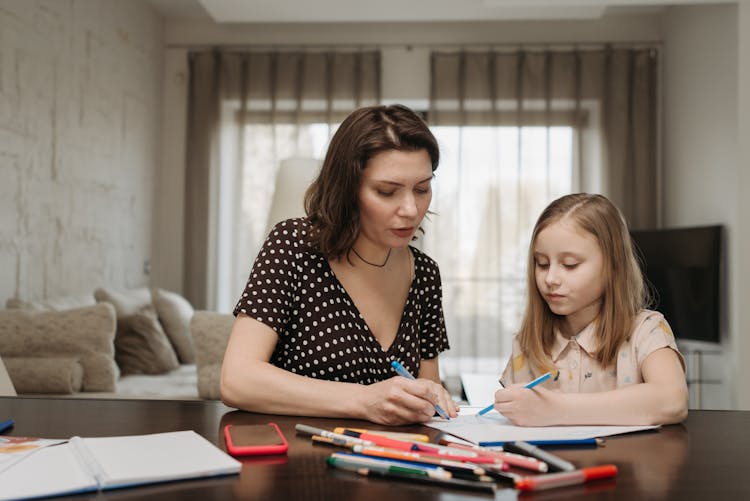 Mother And Daughter Drawing At The Table