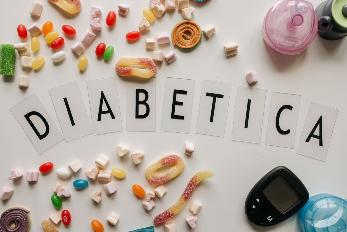 Close-up of candies and diabetes-related items on a white surface, featuring the word 'DIABETICA'.
