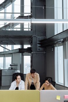 Three professionals collaborating in a modern office space
