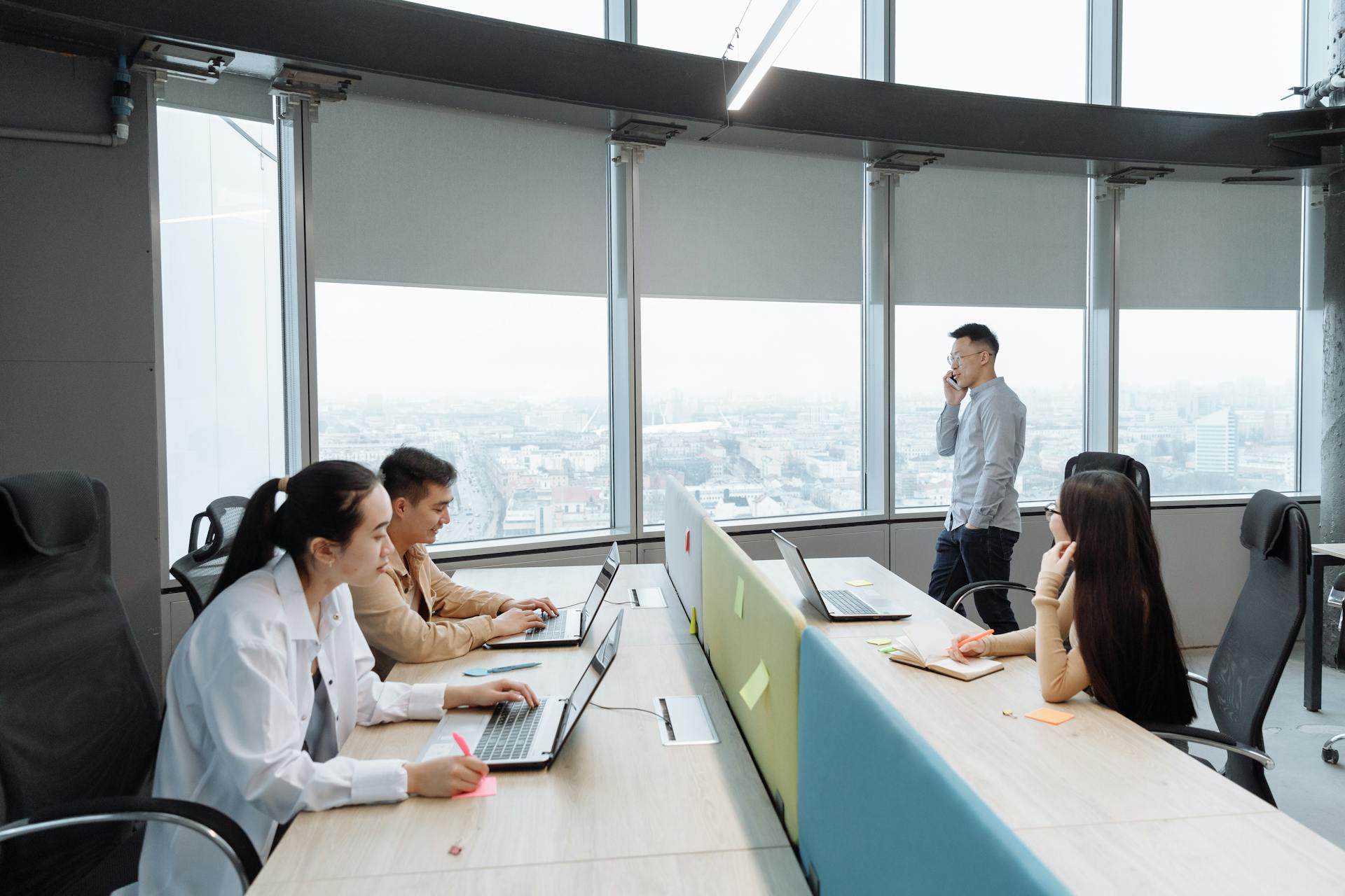 Business team working in a modern office setting with city view.