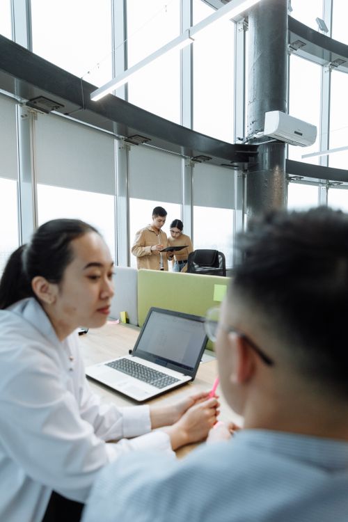 Free Diverse team collaborating in a high-rise office environment with laptops and digital devices. Stock Photo