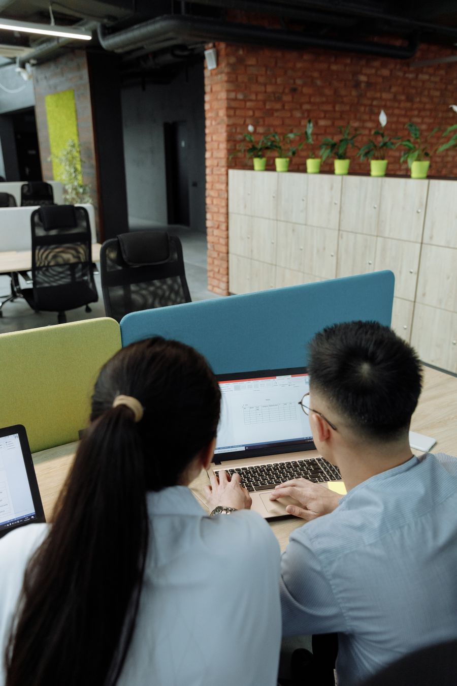 Two colleagues working side by side on a laptop in an open-plan studio — Thirdman on Pexels