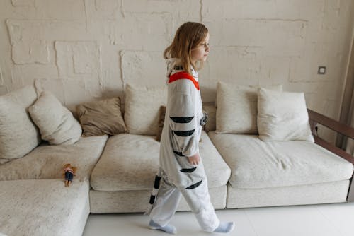 A Girl Wearing Sleepwear Walking in the Living Room while Looking Afar