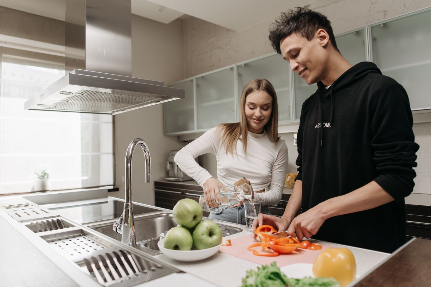 Casal preparando uma refeição com vegetais em uma cozinha real
