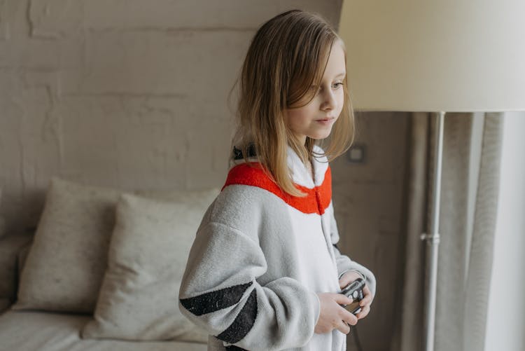 
A Girl Wearing A Onesie Holding An Insulin Pump