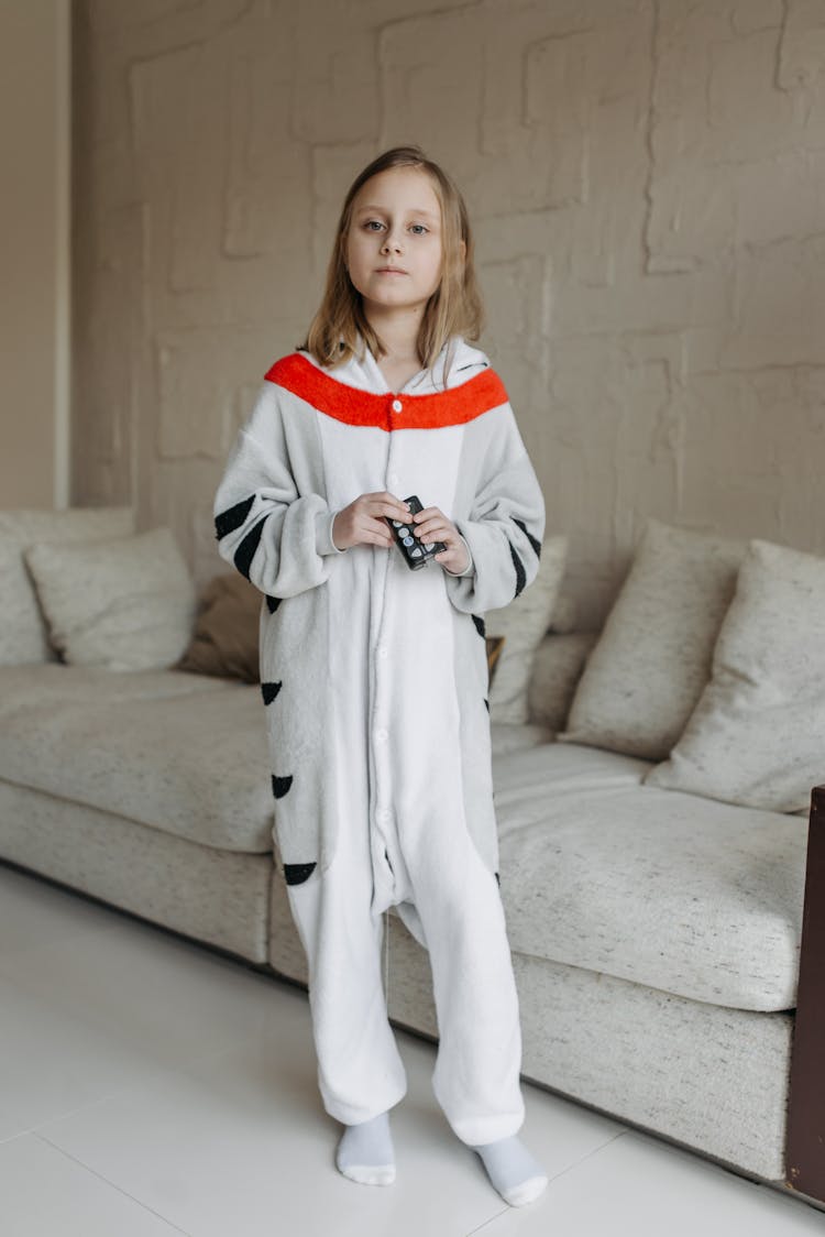 A Girl Wearing A Onesie Holding An Insulin Pump