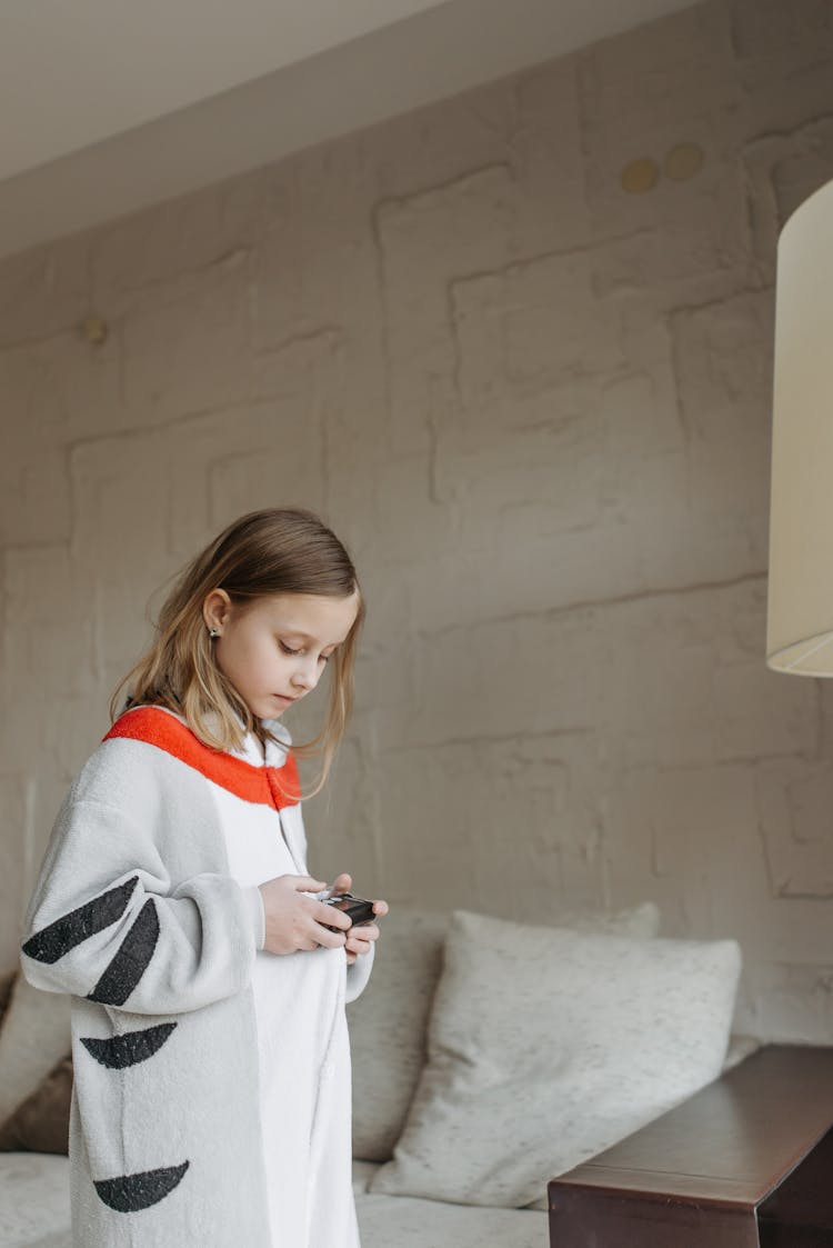 A Girl Wearing A Onesie Holding An Insulin Pump