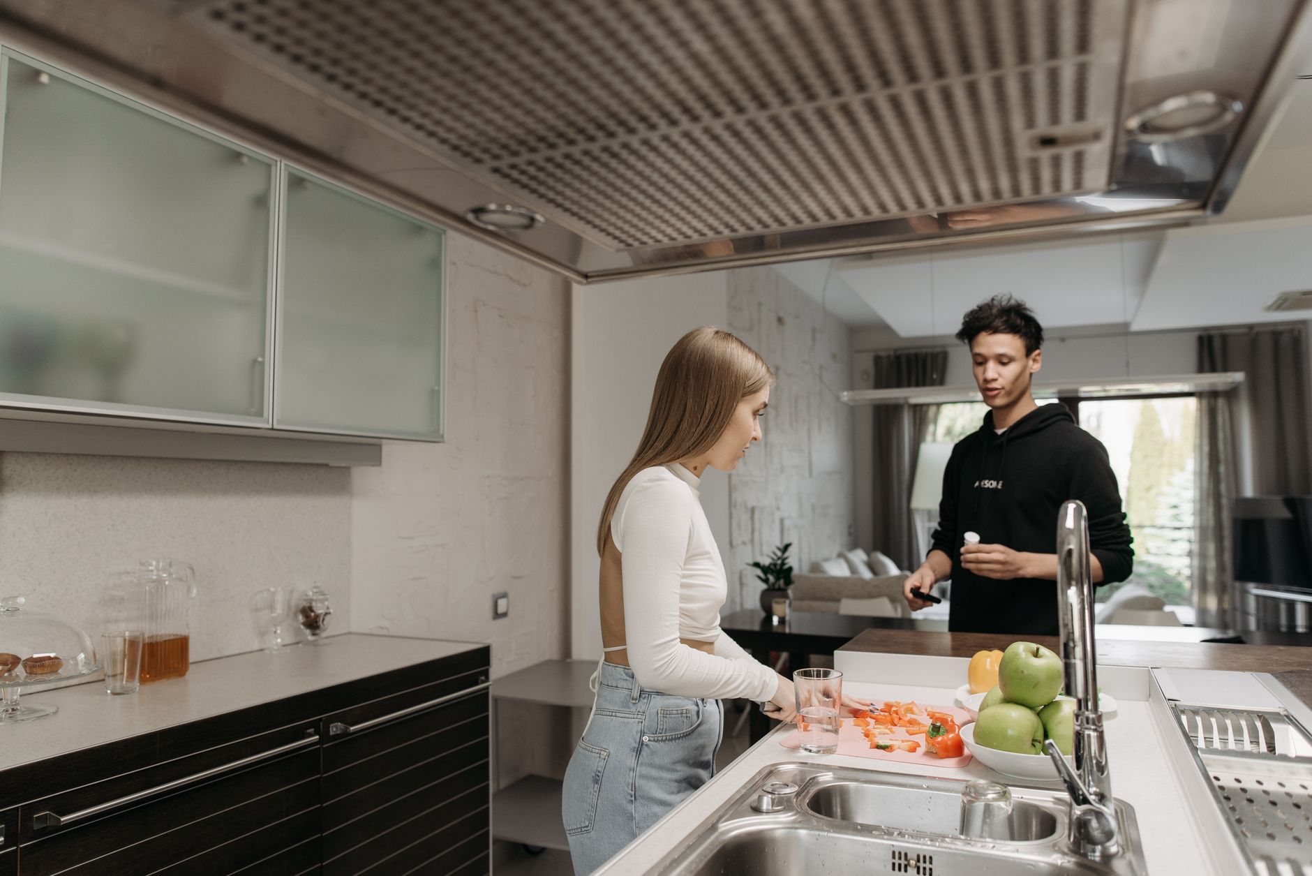 A couple in a modern kitchen engaged in food preparation, showcasing a cozy at-home atmosphere.