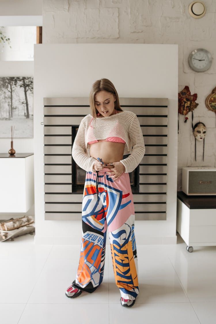 Woman In Pink Printed Pants Standing Beside White Wall