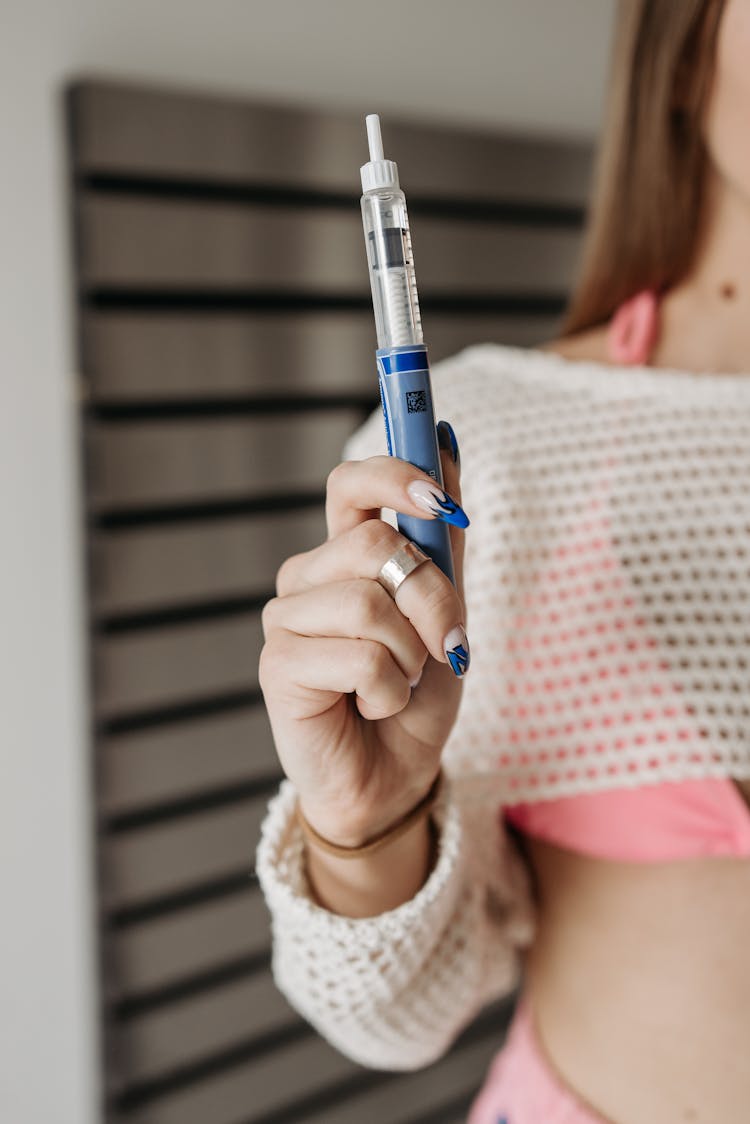 Person Holding Blue And Silver Glucometer