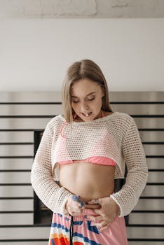 Young woman administering insulin injection, showcasing diabetes management indoors.