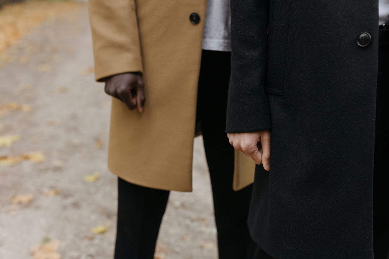 close up of two men wearing fashionable coats outdoors on an autumn da