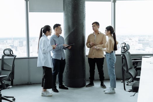 Diverse team discussing ideas in a modern office with city view, fostering collaboration.