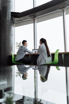 Two professionals working together in a modern, light-filled office space.