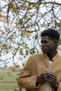 Man in Yellow Sweater Standing Near Tree