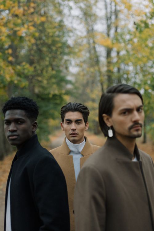 Free Three stylish men posing confidently in an autumn forest, showcasing diverse fashion and style. Stock Photo