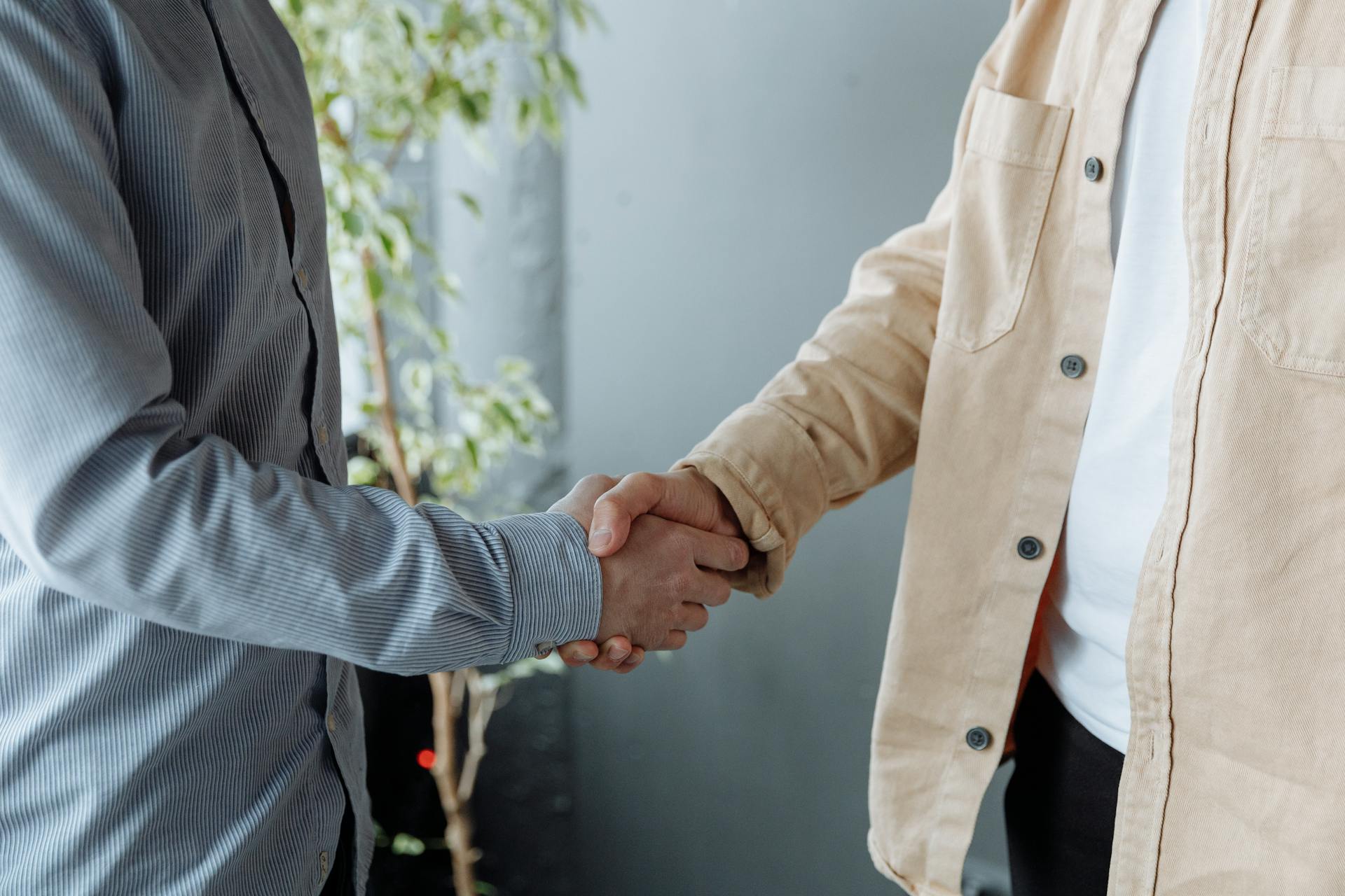 A close-up image of two businesspeople shaking hands in an office environment symbolizing agreement and partnership.