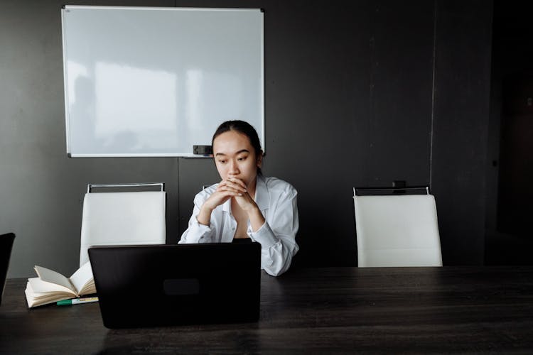 Woman Thinking While Looking At Laptop