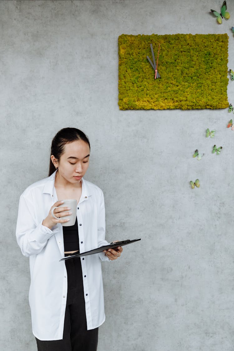 Woman Holding A Mug And A Clipboard