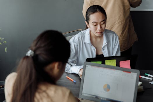 Young professionals collaborating in a modern office with laptops and documents.