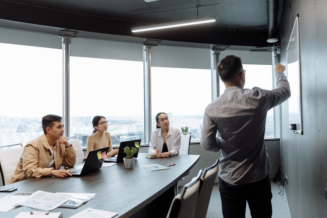 Photo of a Man Presenting at a Meeting