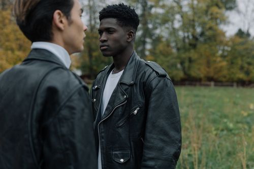 Free Two fashionable men wearing leather jackets in a serene outdoor setting. Stock Photo