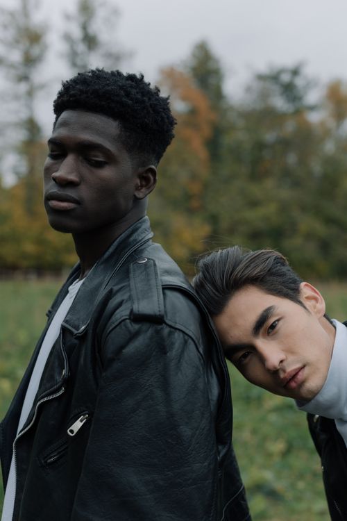 Free Two stylish men posing in a natural outdoor setting with a serene expression. Stock Photo