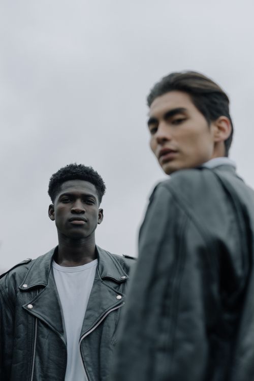Free Two stylish men in leather jackets facing each other outdoors, conveying modern fashion and attitude. Stock Photo