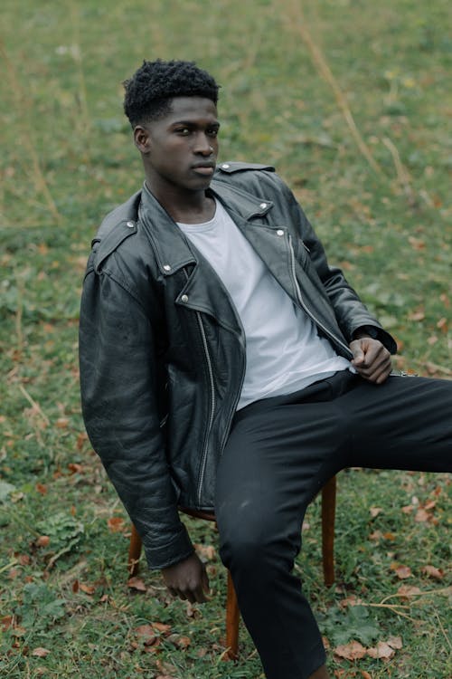 Man in Black Leather Jacket Sitting on a Stool