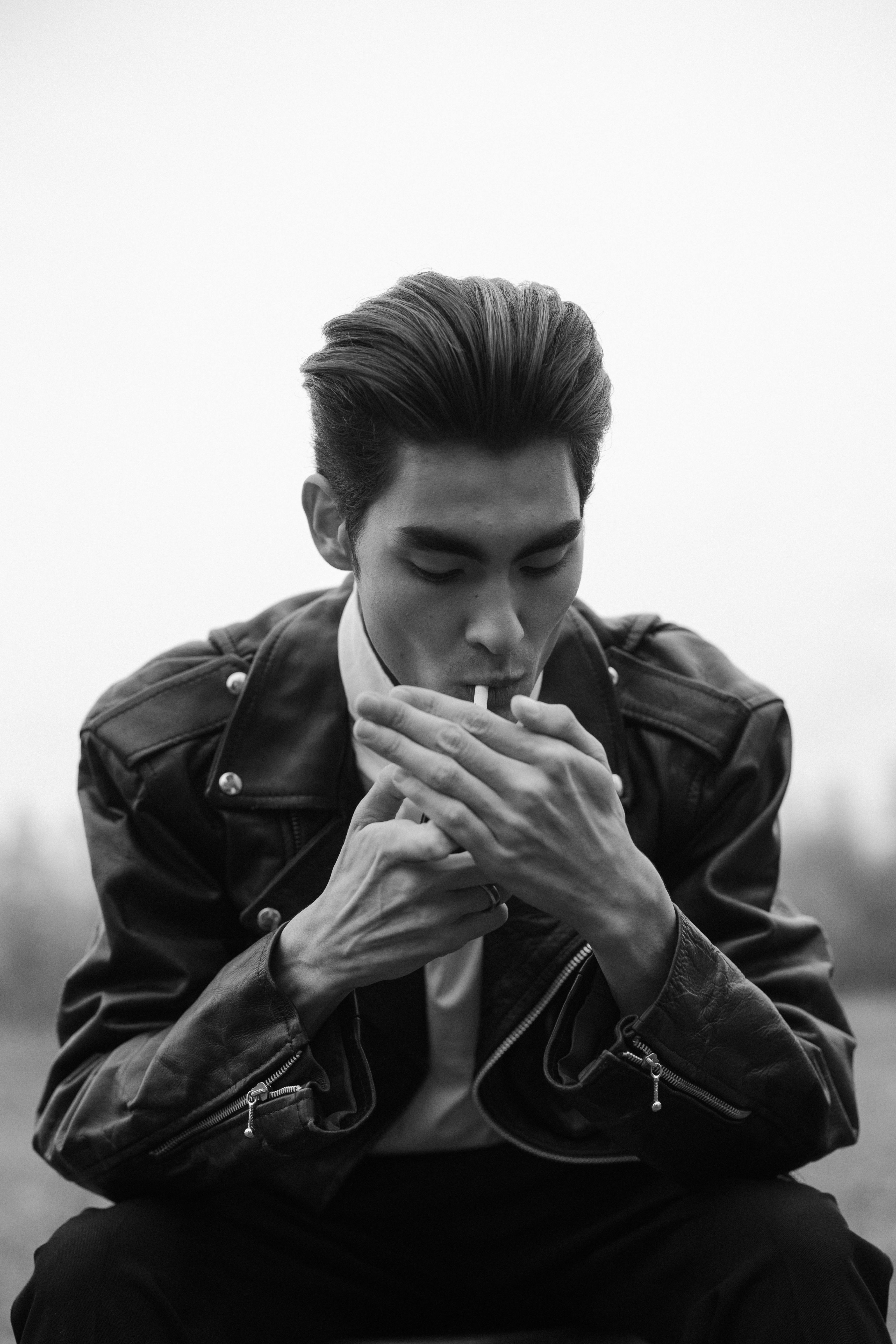 black and white photo of a man lighting a cigarette