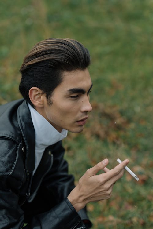 Man Wearing Leather Jacket Smoking a Cigarette