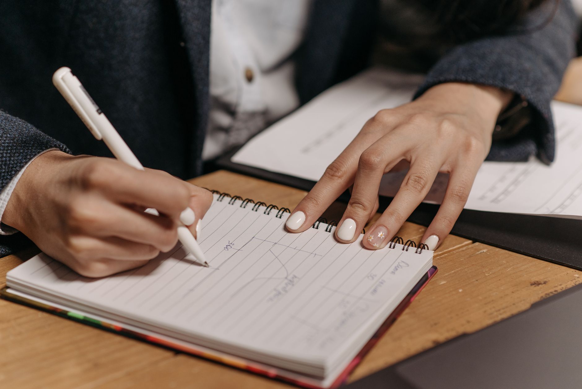 Close-up of writing key points in a notebook