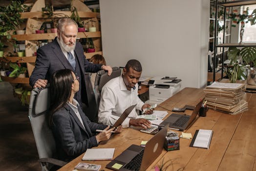 A diverse team of professionals collaborating in a modern office setting, focused on documents.