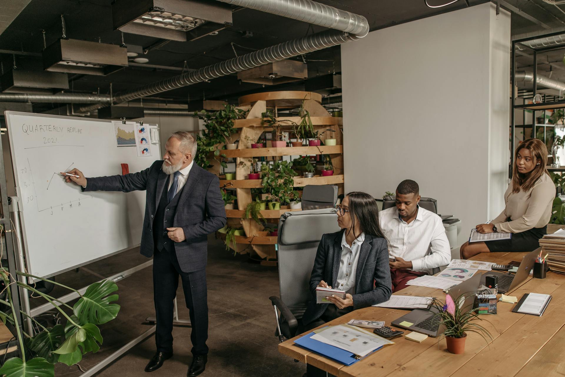 Team in a modern office discussing quarterly earnings with a presentation.