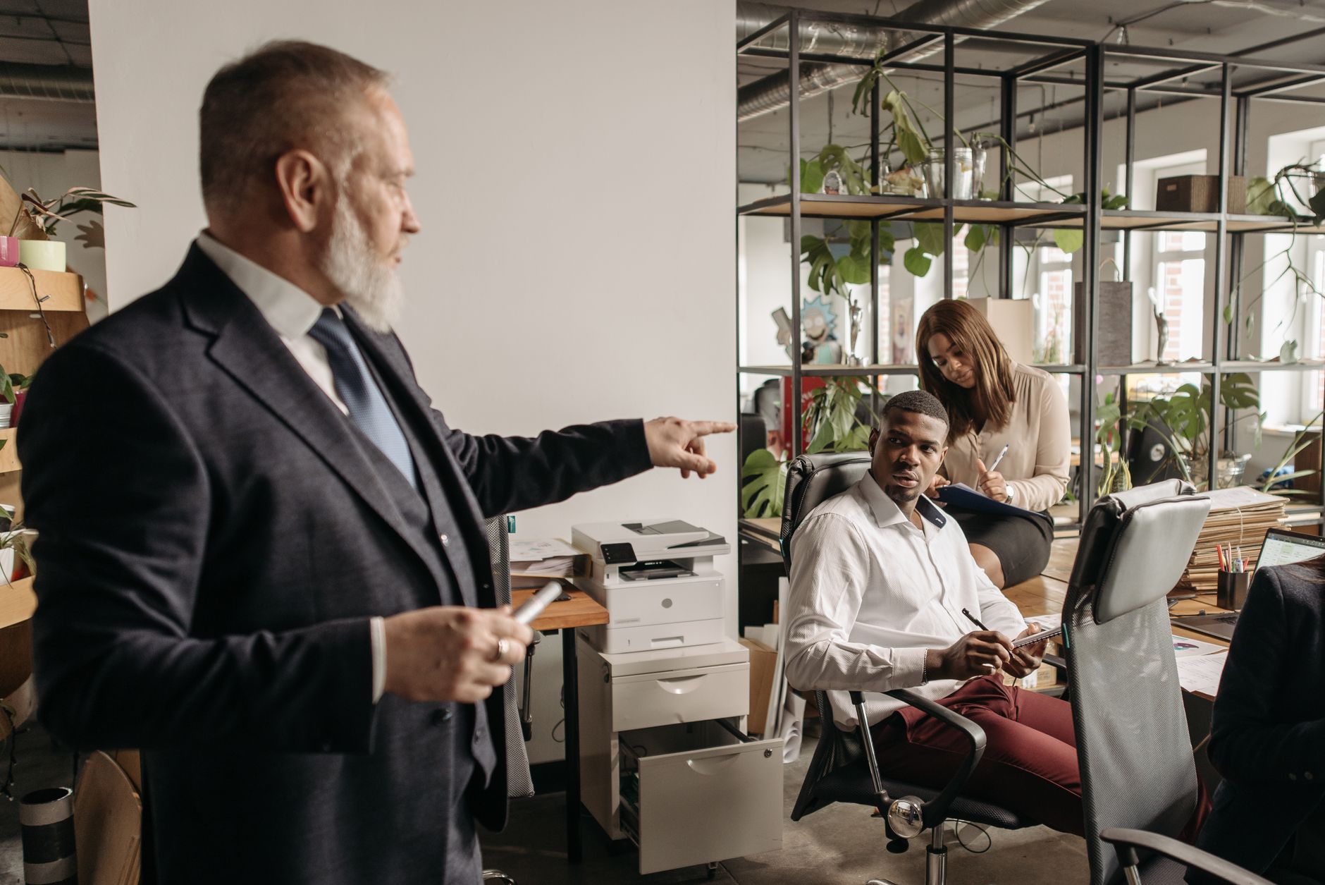 Diverse colleagues engaged in a focused office discussion around a desk.