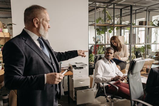 Diverse colleagues engaged in a focused office discussion around a desk.