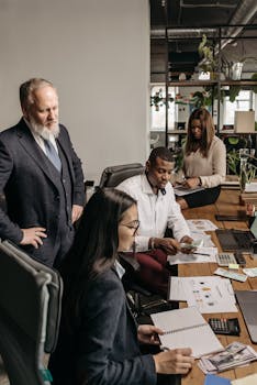 Office team working together on a business project with documents and laptops.