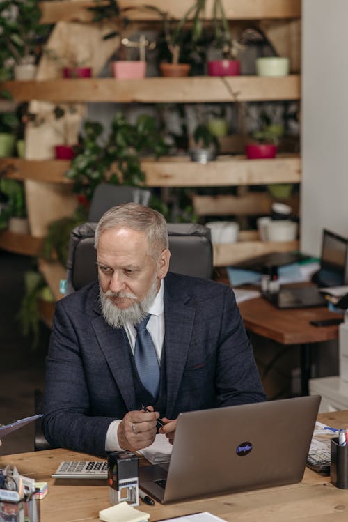 Free Man in Black Suit Sitting by the Table and Working Stock Photo