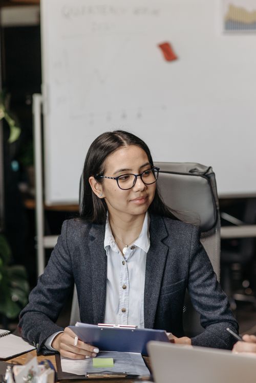 Free Confident businesswoman holding clipboard during a meeting in an office setting. Stock Photo