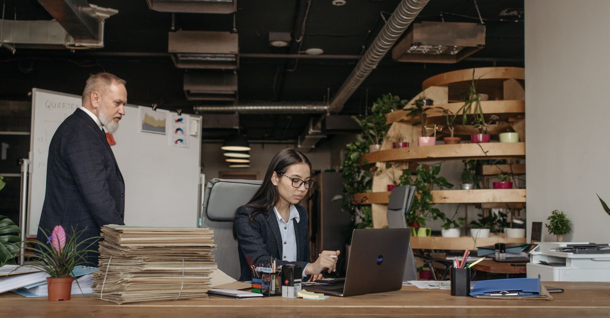 Equipo de negocios en una oficina trabajando juntos con equipos modernos, plantas y documentos.