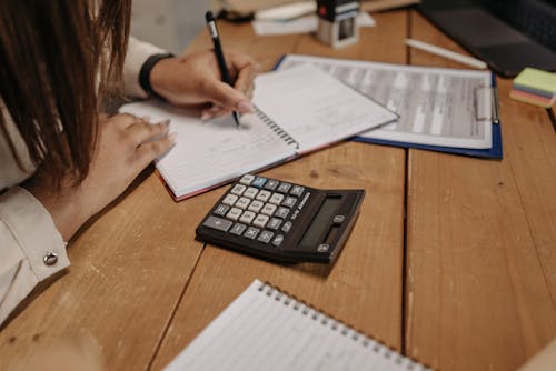 Foto d'estoc gratuïta de boli, calculadora, carpeta amb agafador de papers