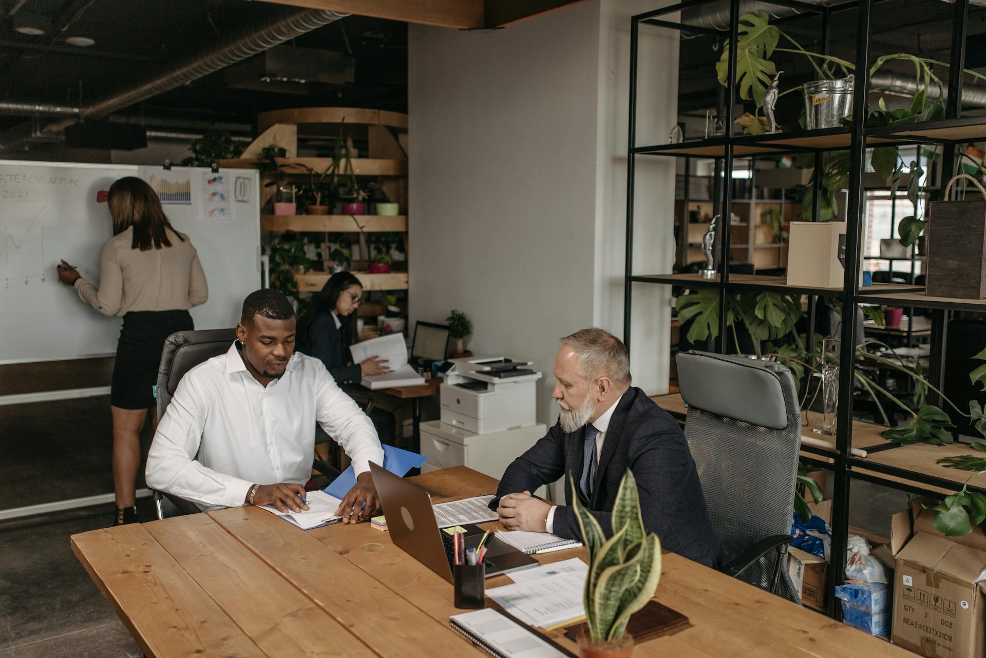 Professional team engaged in a business meeting with diverse members in a modern office environment.