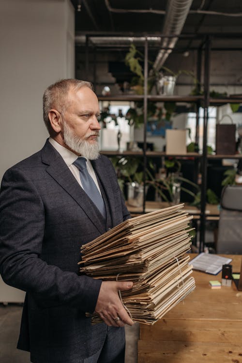 Free An Elderly Man Carrying a Bunch of Documents Stock Photo
