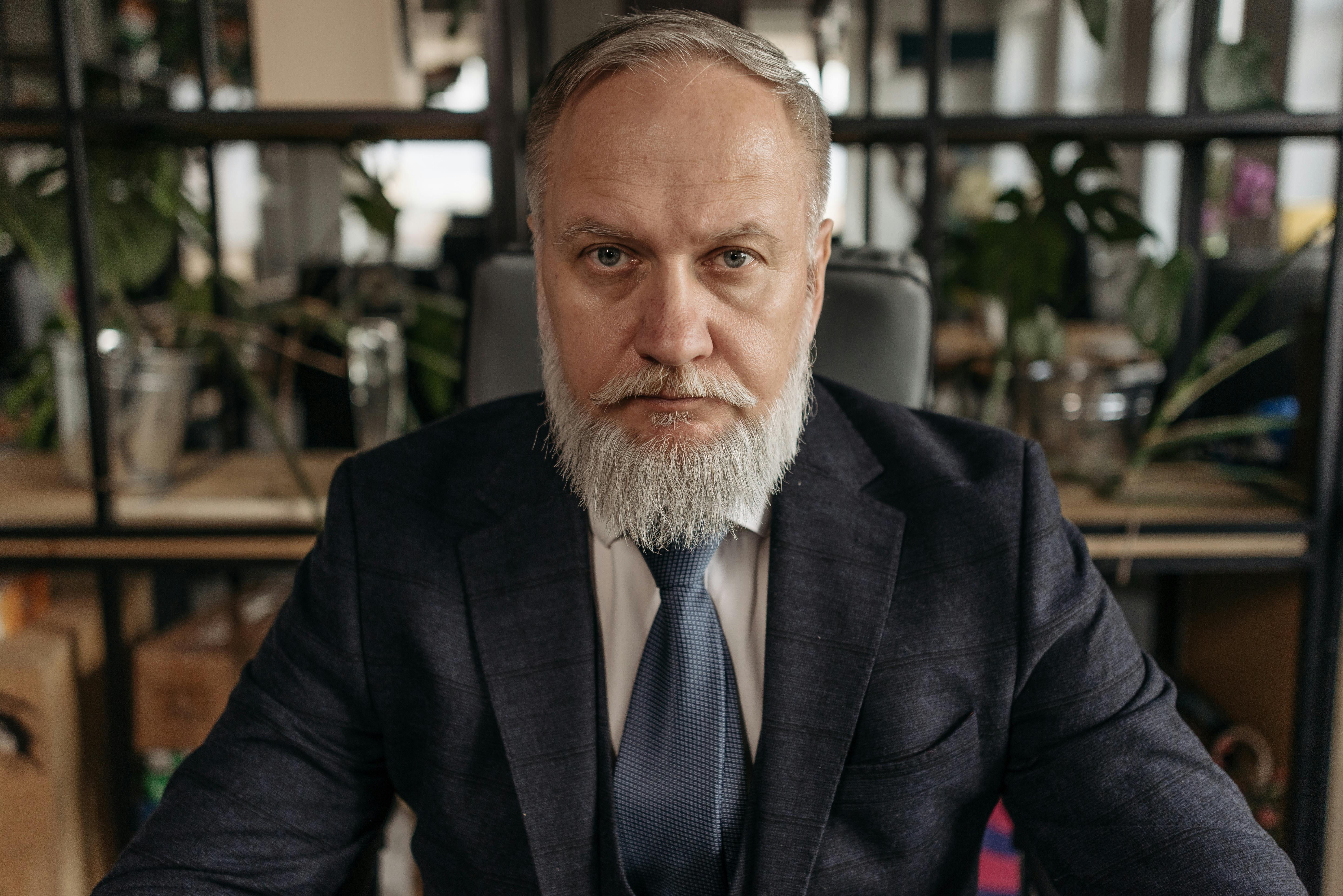 A Man in Gray Suit Typing on His Laptop · Free Stock Photo