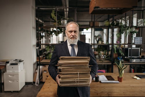 Elderly Man in Black Suit Carrying Document Folders