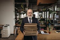 Elderly Man in Black Suit Carrying Document Folders
