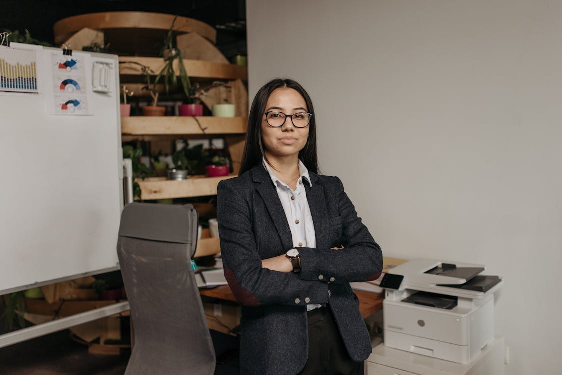 Free Woman in Gray Blazer Standing in the Office Stock Photo